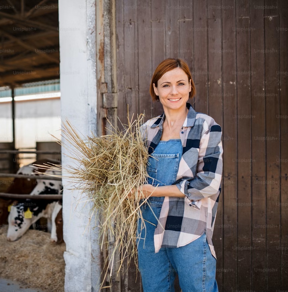 ginger woman smiling while holding hay